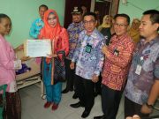 Bupati Tanggamus Hj. Dewi Handajani, Serahkan Secara Simbolis Akte Kelahiran, Kartu Keluarga (KK) Dan Kartu Identitas Anak (KIA) Di Puskesmas Kota Agung Tanggamus
