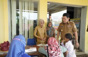 Tinjau Pelayanan Disdukcapil, Pj Bupati Turut Melayani Serahkan KK Kepada Warga